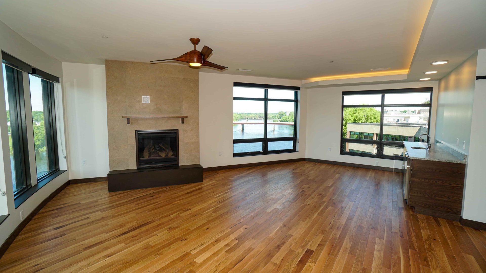 An empty living room with hardwood floors and a fireplace