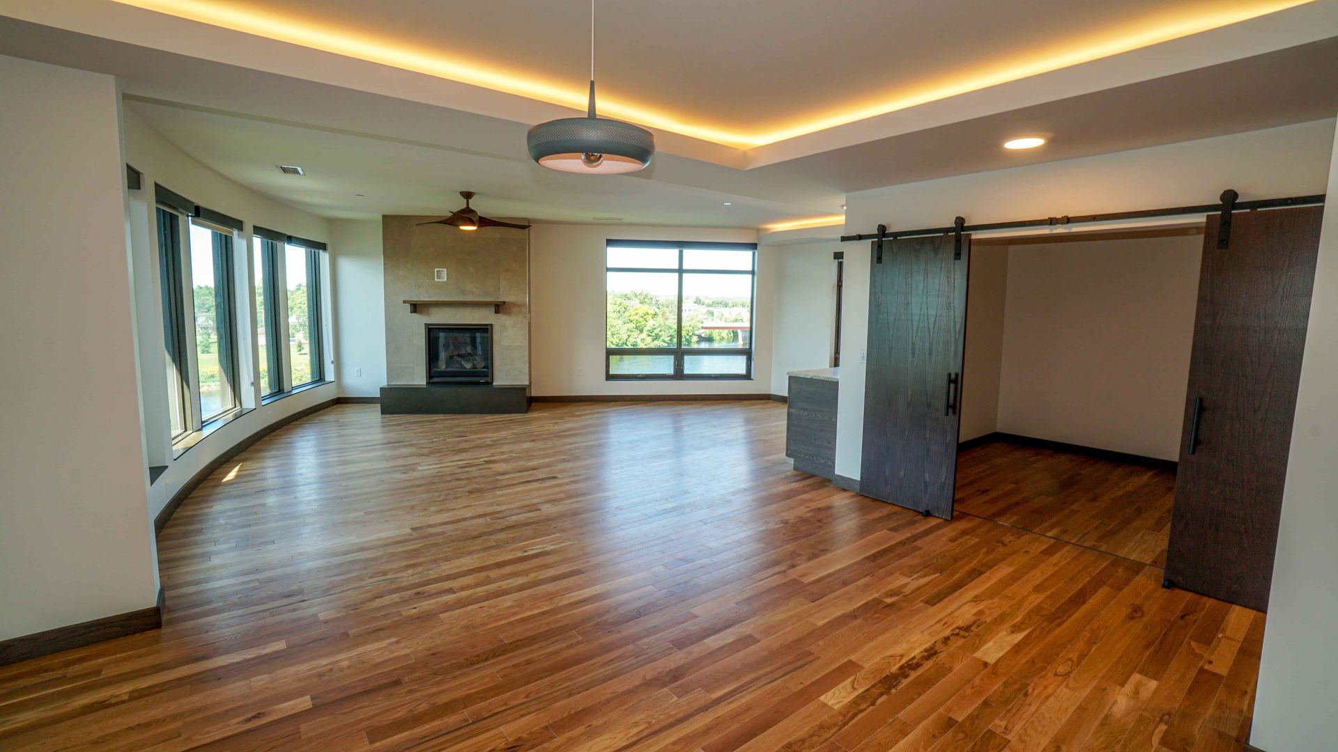 An empty living room with hardwood floors and a fireplace.