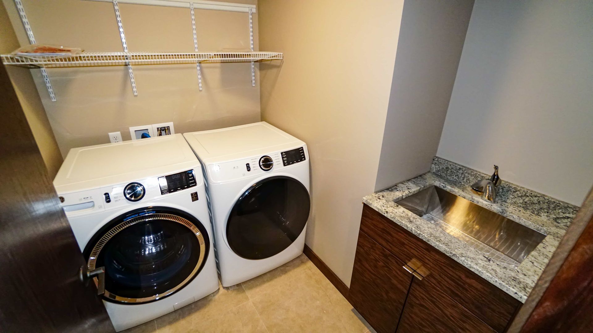 A laundry room with a washer and dryer and a sink.