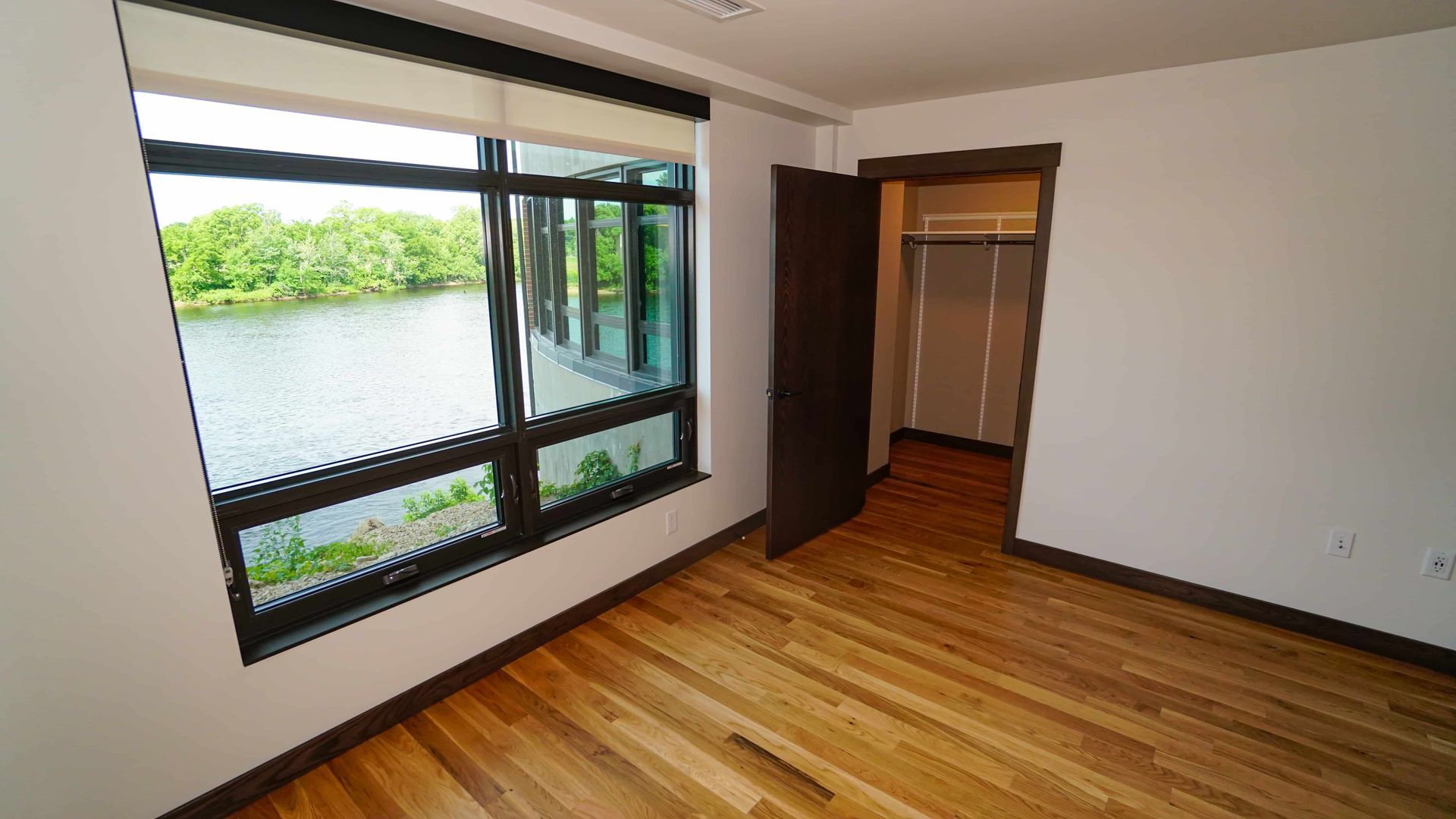 An empty room with a large window and a closet