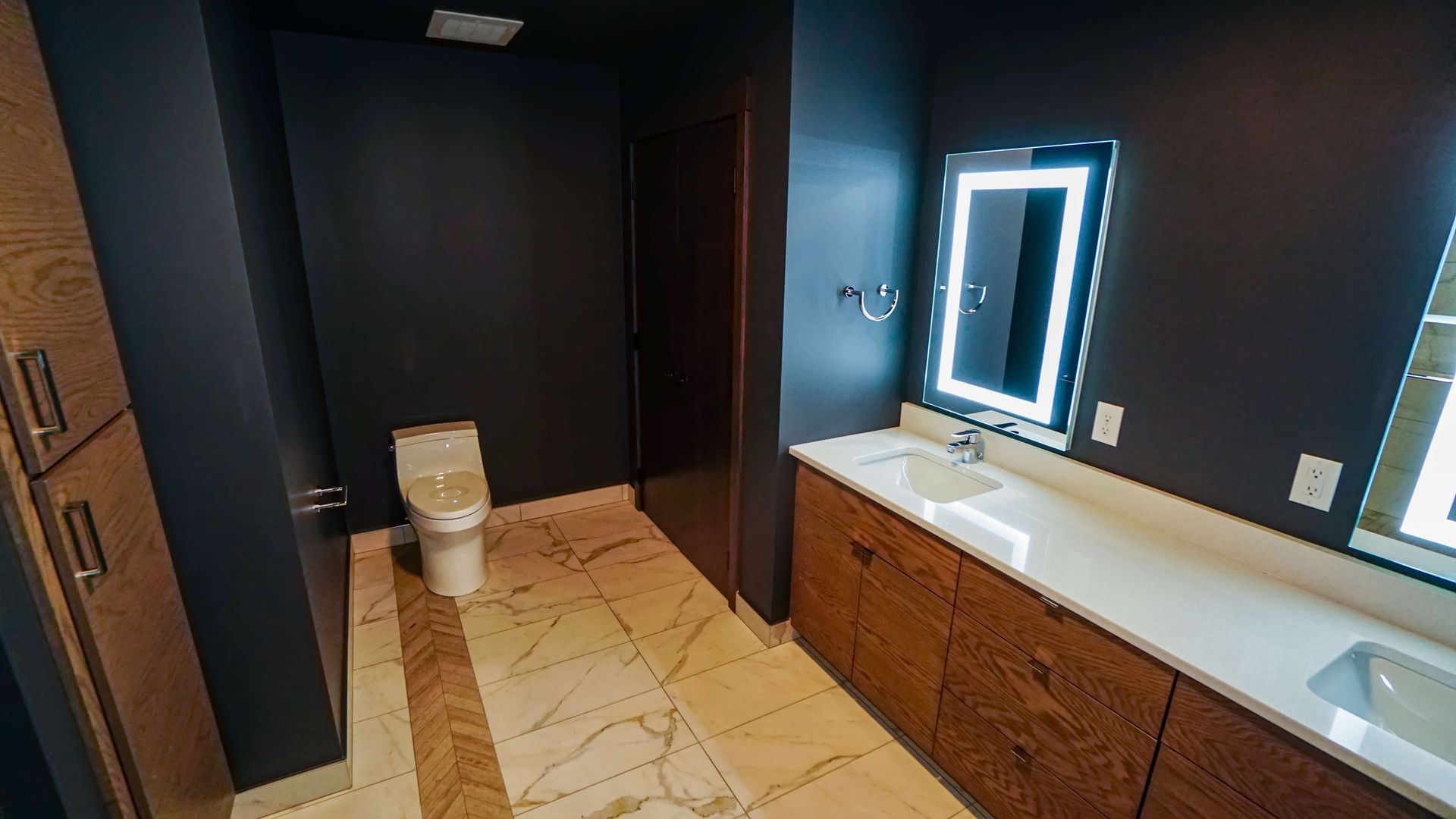 A bathroom with a toilet , sink and mirror.