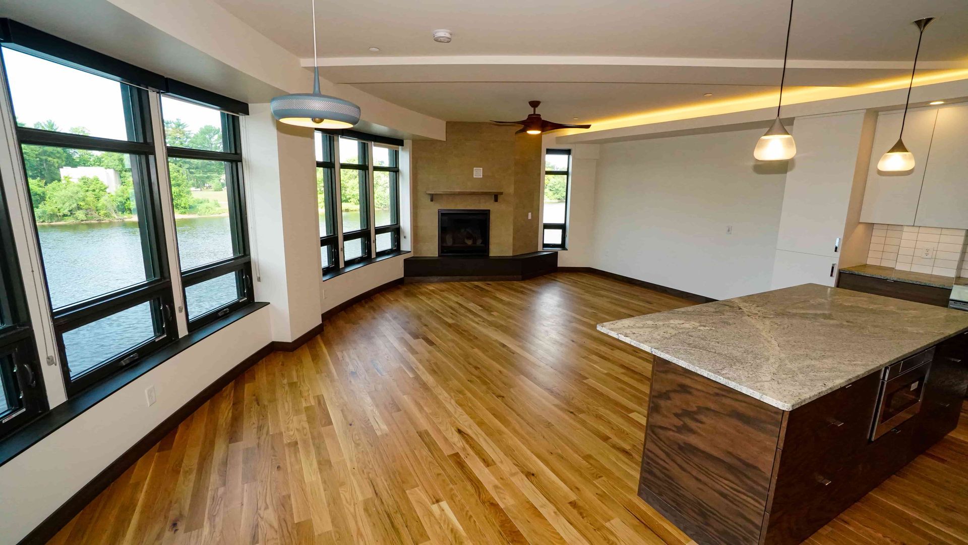 An empty living room with hardwood floors and a fireplace