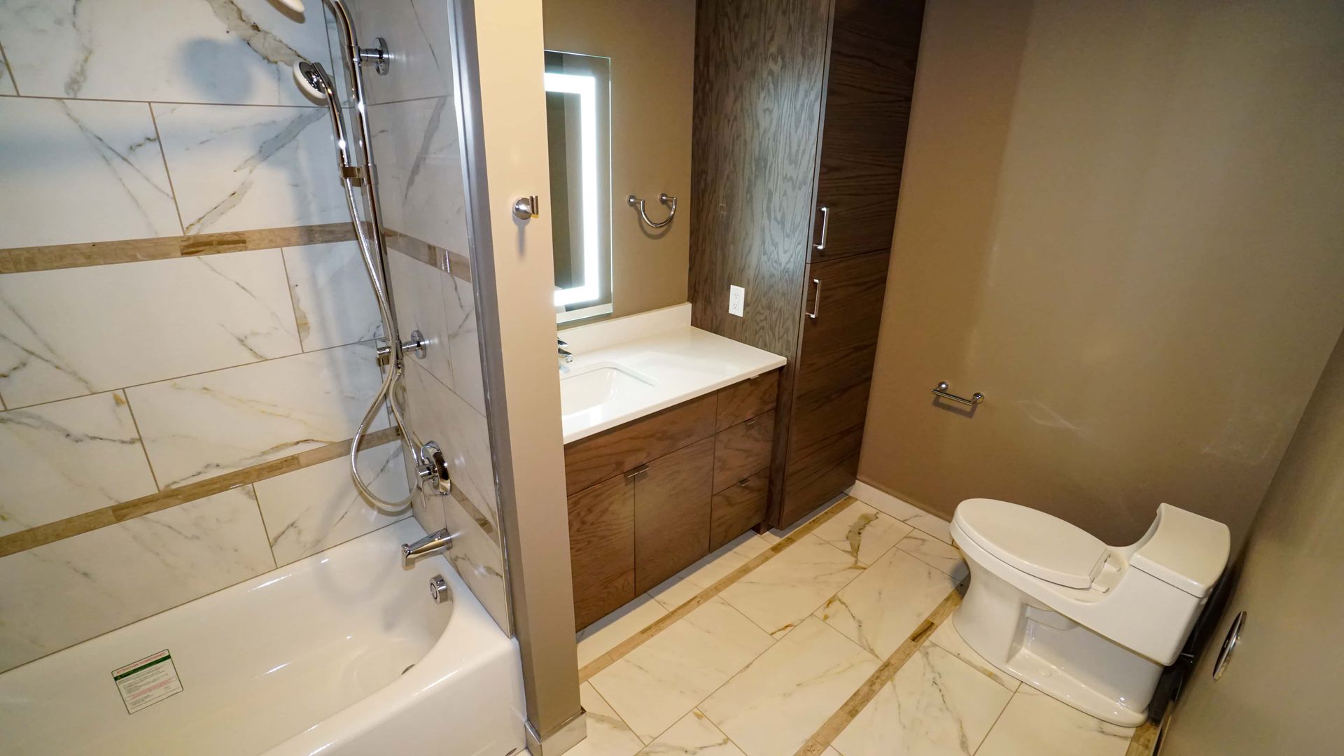 A bathroom with a toilet , tub , sink and shower.