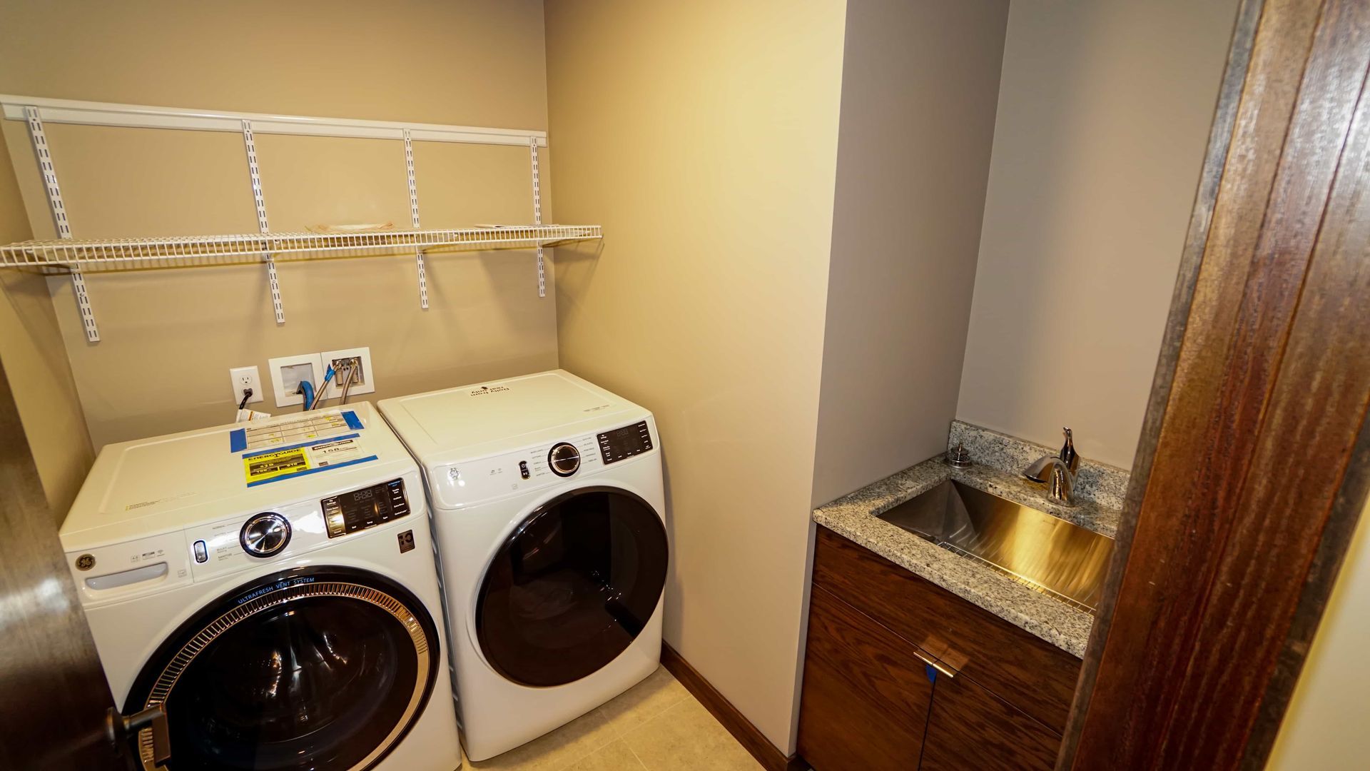 A laundry room with a washer and dryer and a sink.