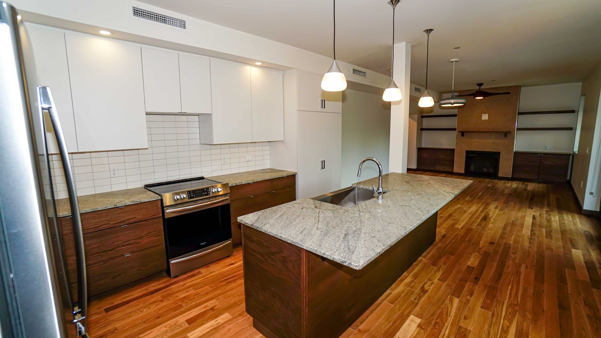 A kitchen with stainless steel appliances , granite counter tops , and hardwood floors.