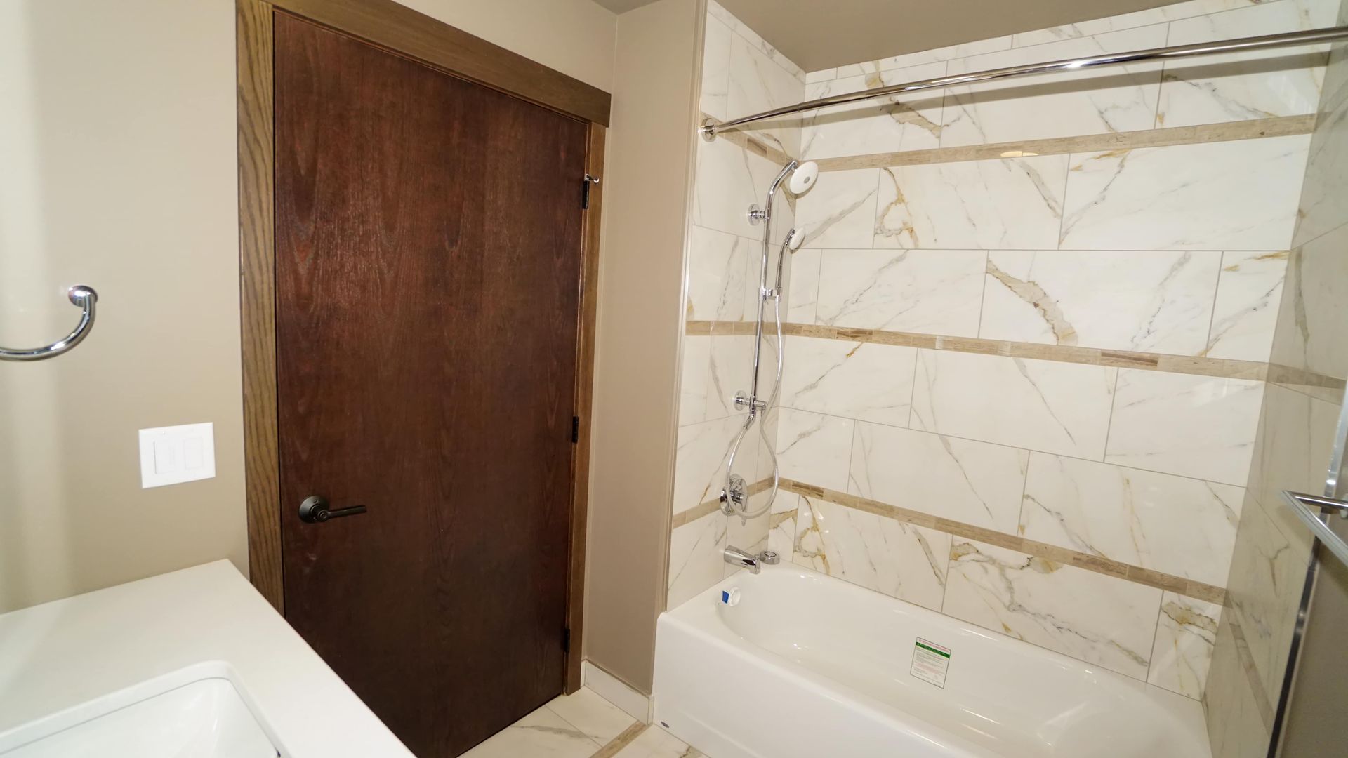 A bathroom with a tub , sink and shower.