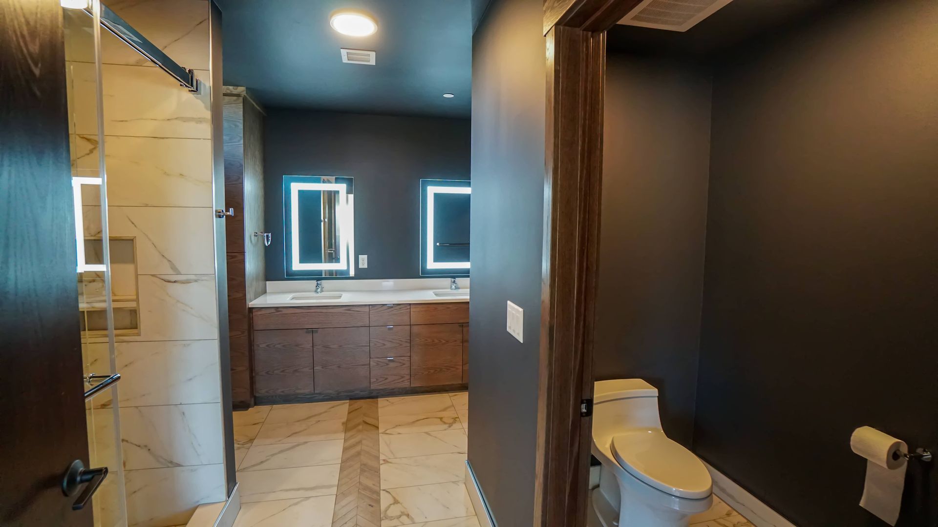 A bathroom with a toilet , sink and shower.