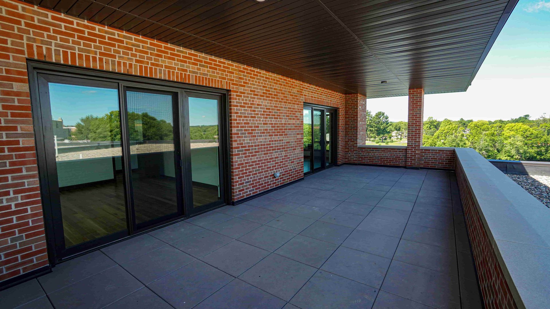 A large brick building with a balcony and sliding glass doors.