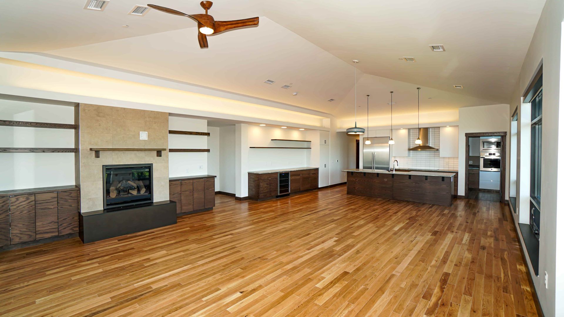 A large empty living room with hardwood floors and a fireplace.
