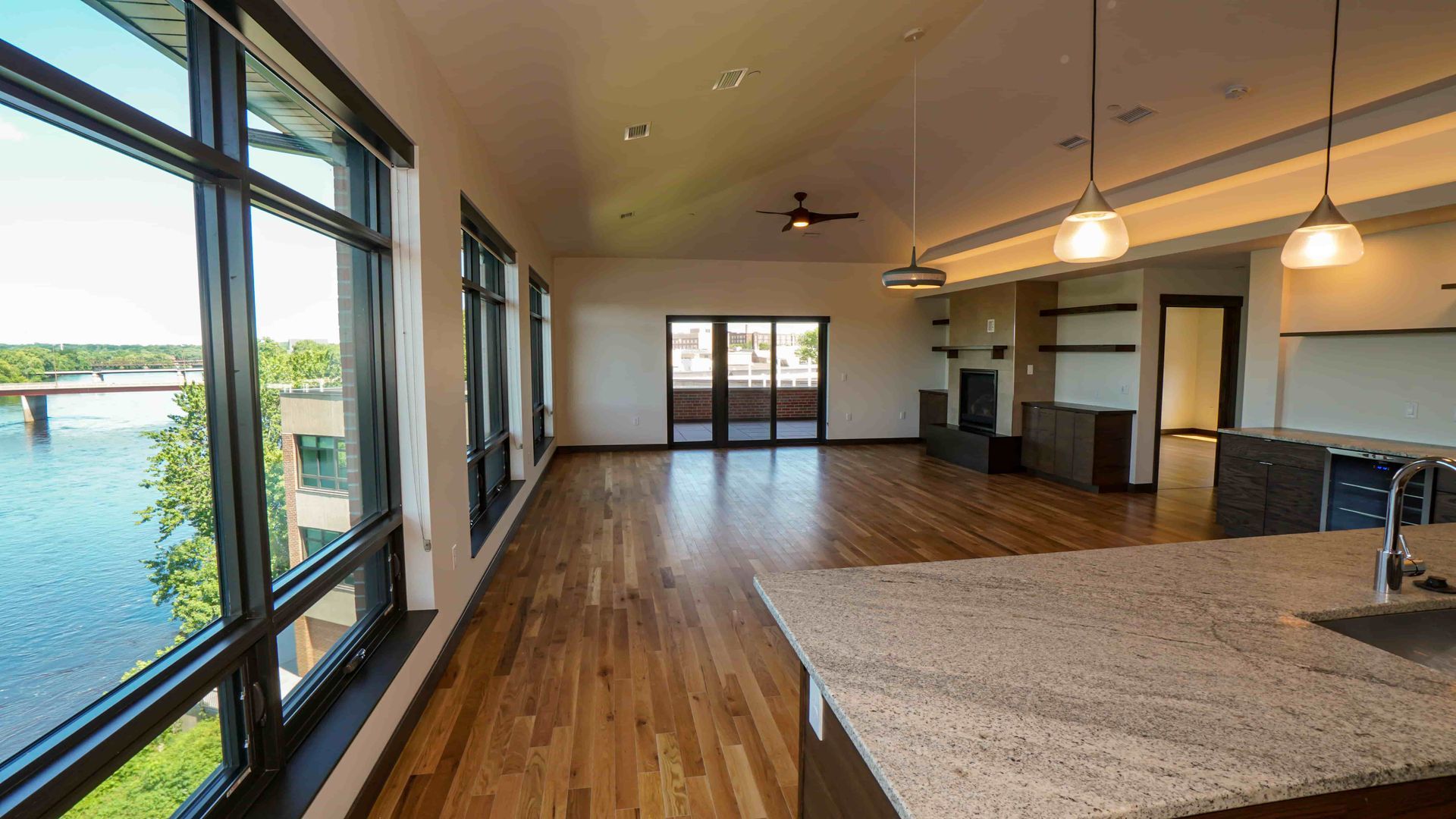 A large empty room with a lot of windows and a view of a river.