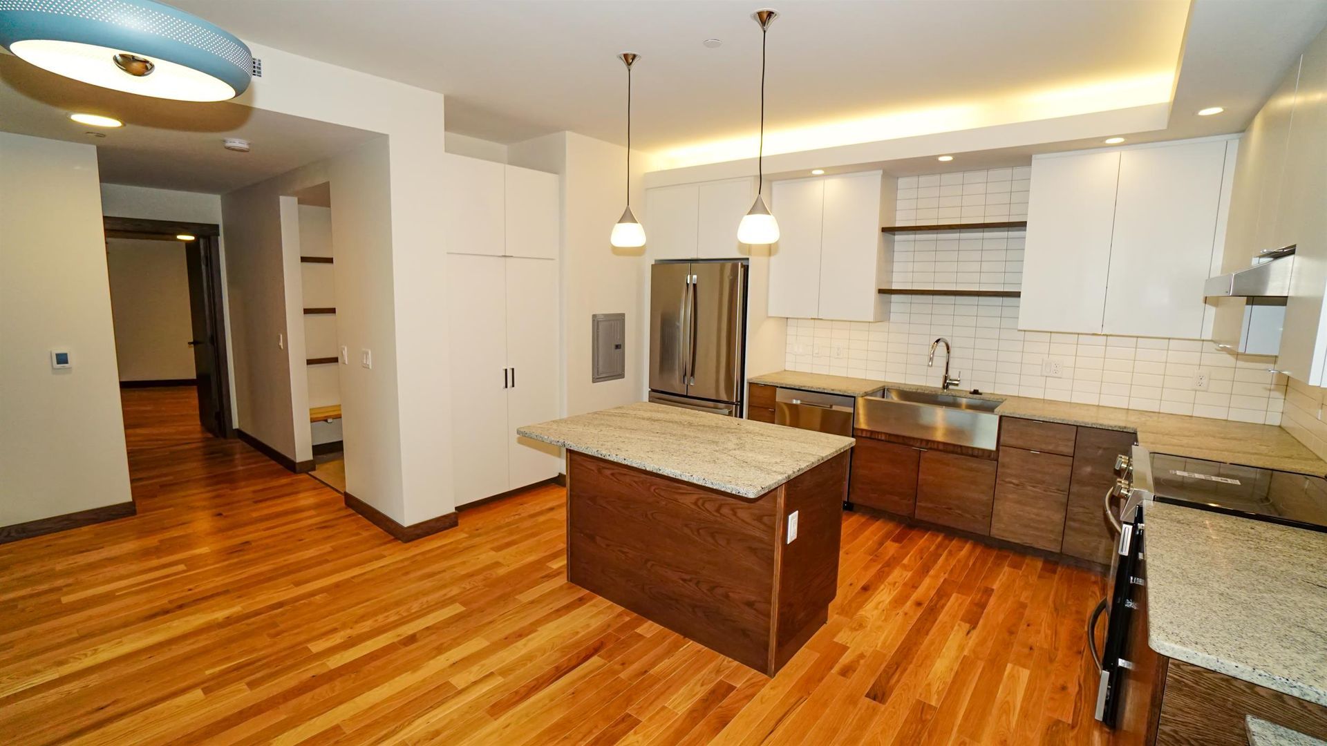 A kitchen with hardwood floors and stainless steel appliances