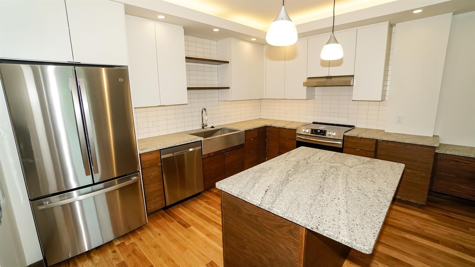 A kitchen with stainless steel appliances and granite counter tops.