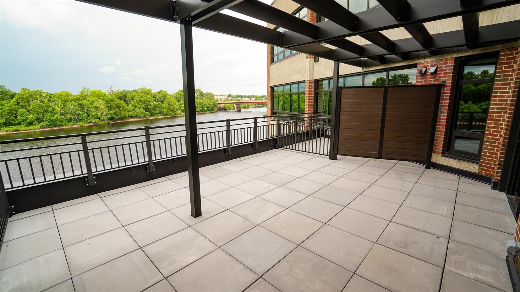 A large patio with a view of a river and trees.