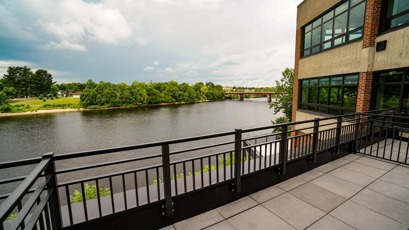 A balcony overlooking a body of water with a bridge in the background.