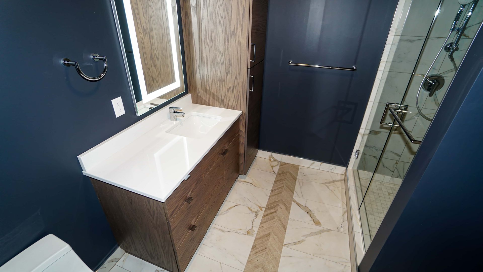 A bathroom with a sink , toilet and shower.