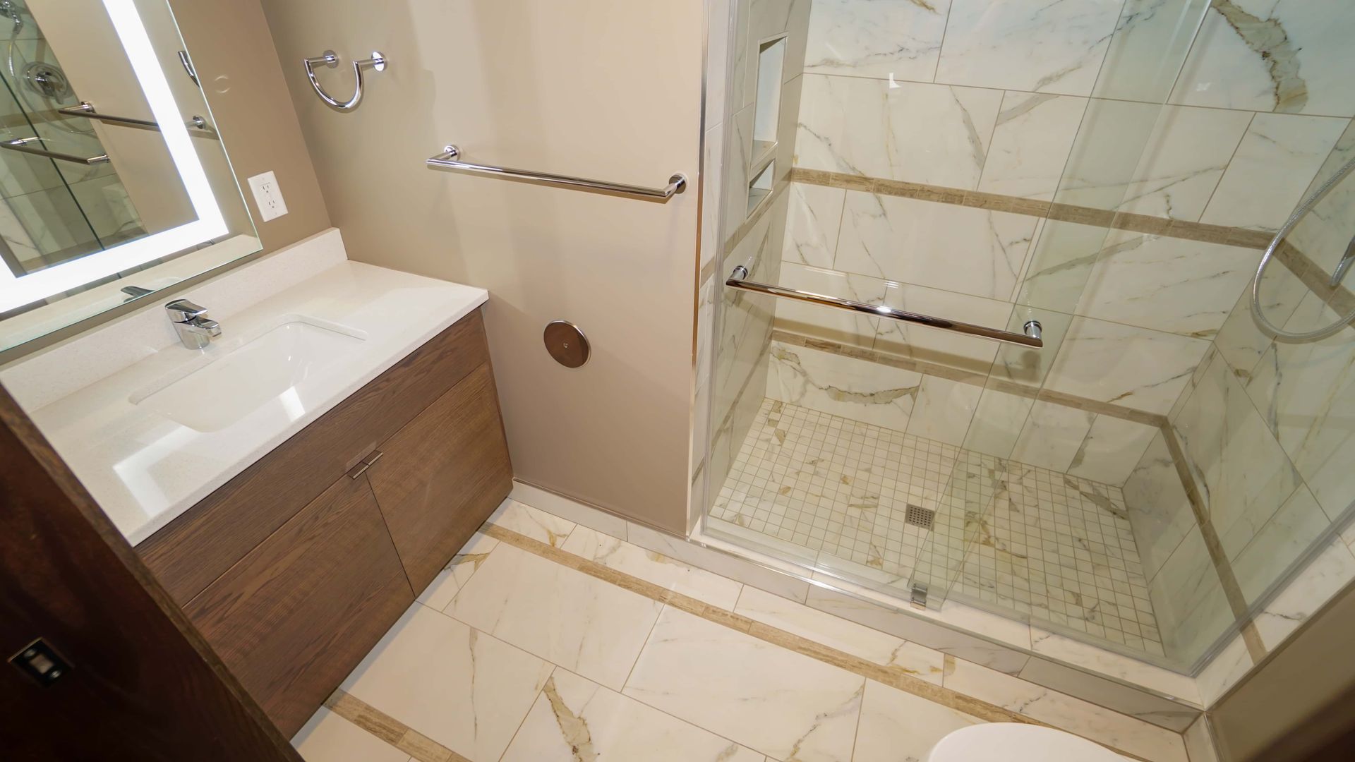 A bathroom with a sink , toilet and walk in shower.