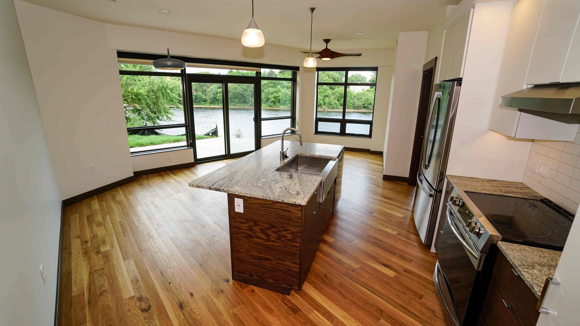 An empty kitchen with hardwood floors and a large island