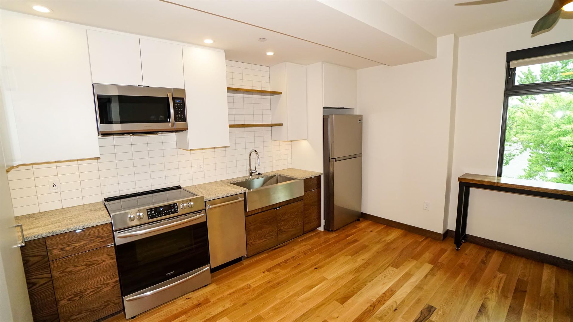 A kitchen with stainless steel appliances and wooden floors.