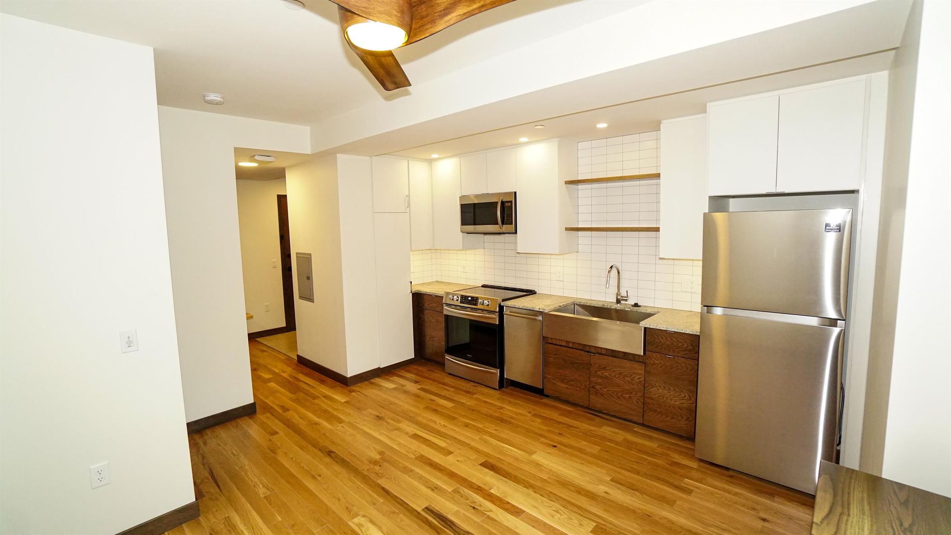 A kitchen with stainless steel appliances and hardwood floors.
