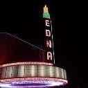 Marquee of Edna Theatre with illuminated sign, black background.