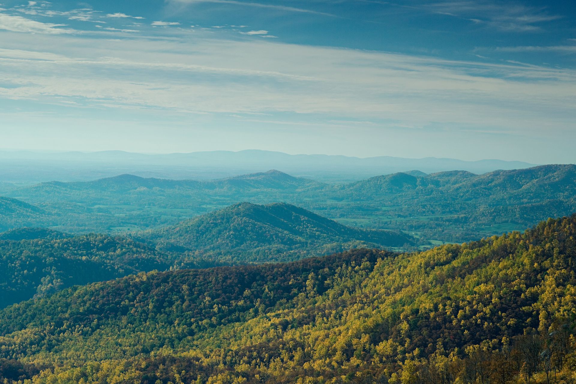 A man is sitting on a couch talking to two older people.