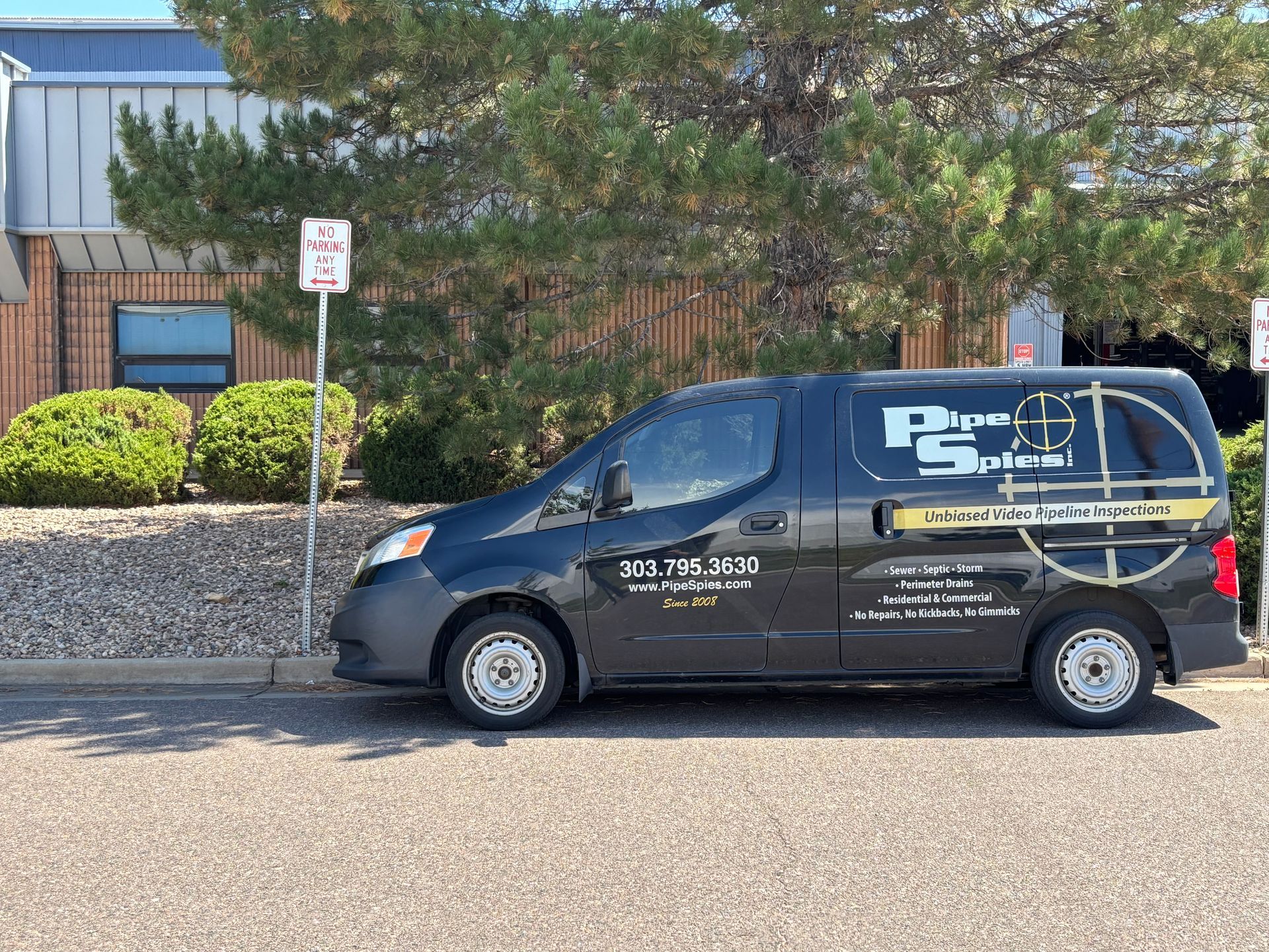 Black van parked outside a building, advertising 