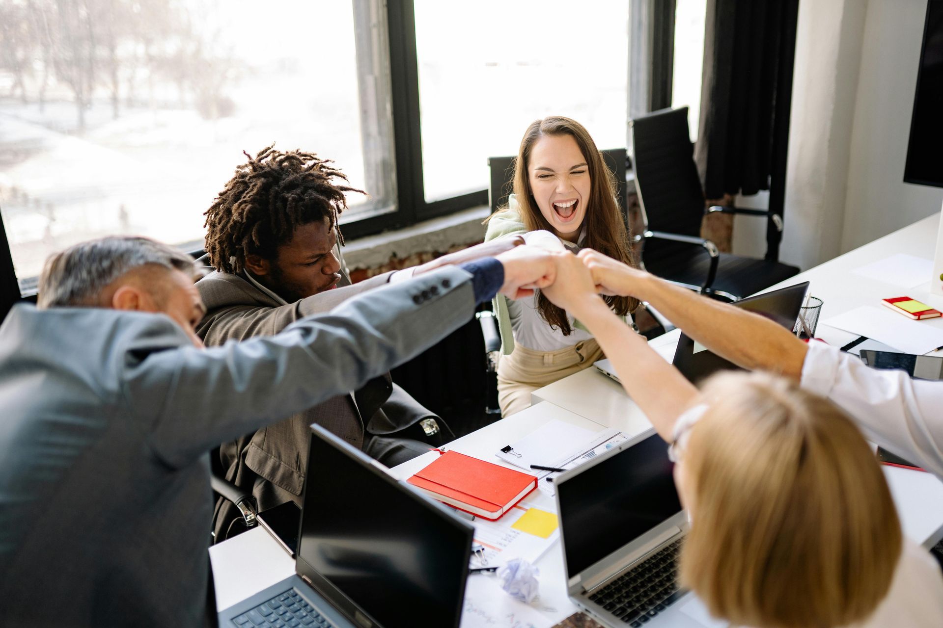 A group of people are putting their hands together in an office.