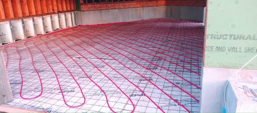 A picture of a concrete floor with red wires coming out of it.