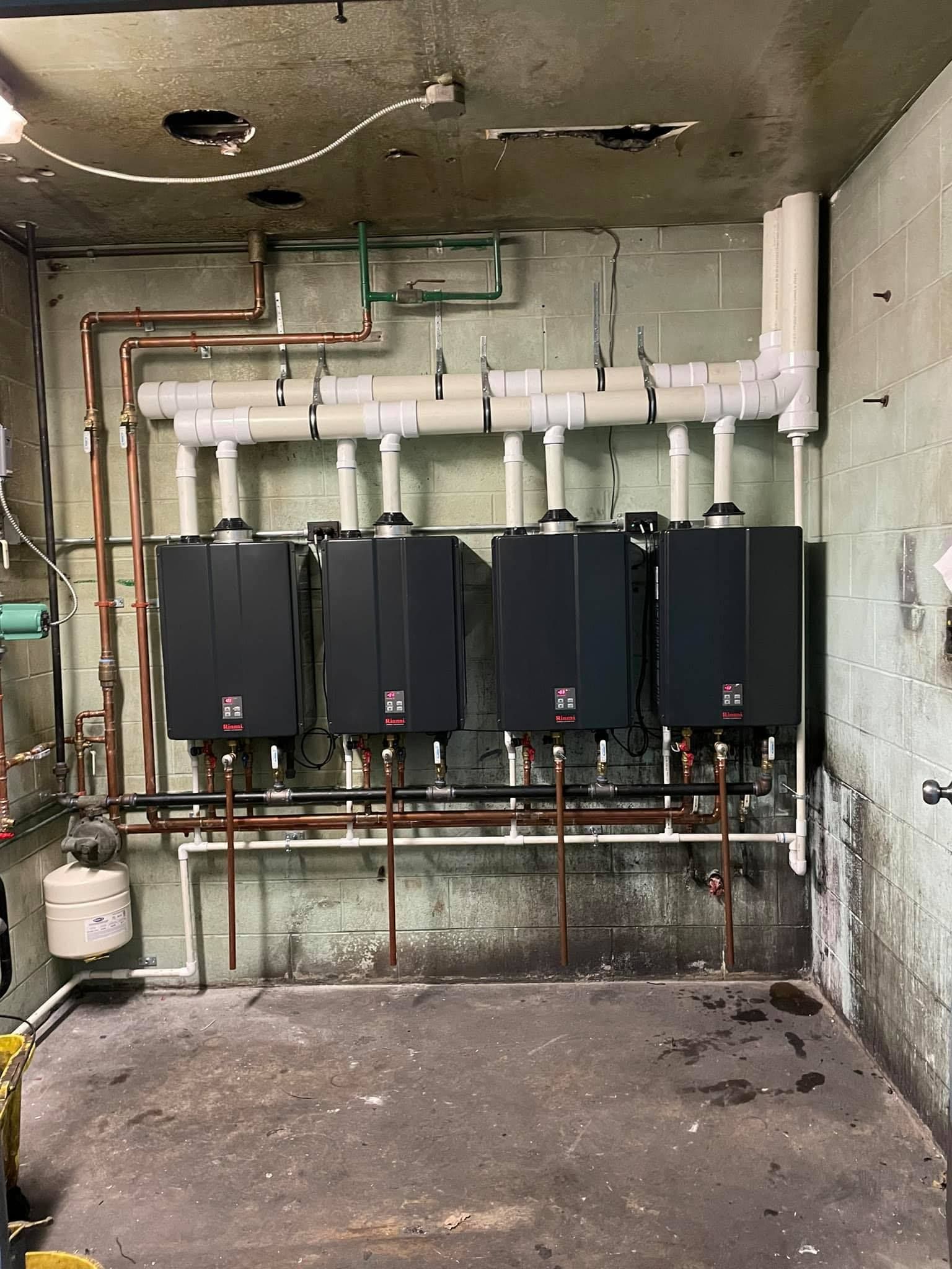 A room with a lot of pipes and boilers on the wall.