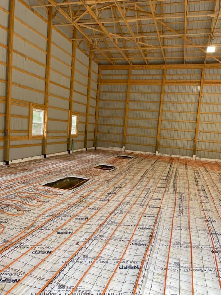 A large warehouse with a concrete floor and a wooden ceiling.