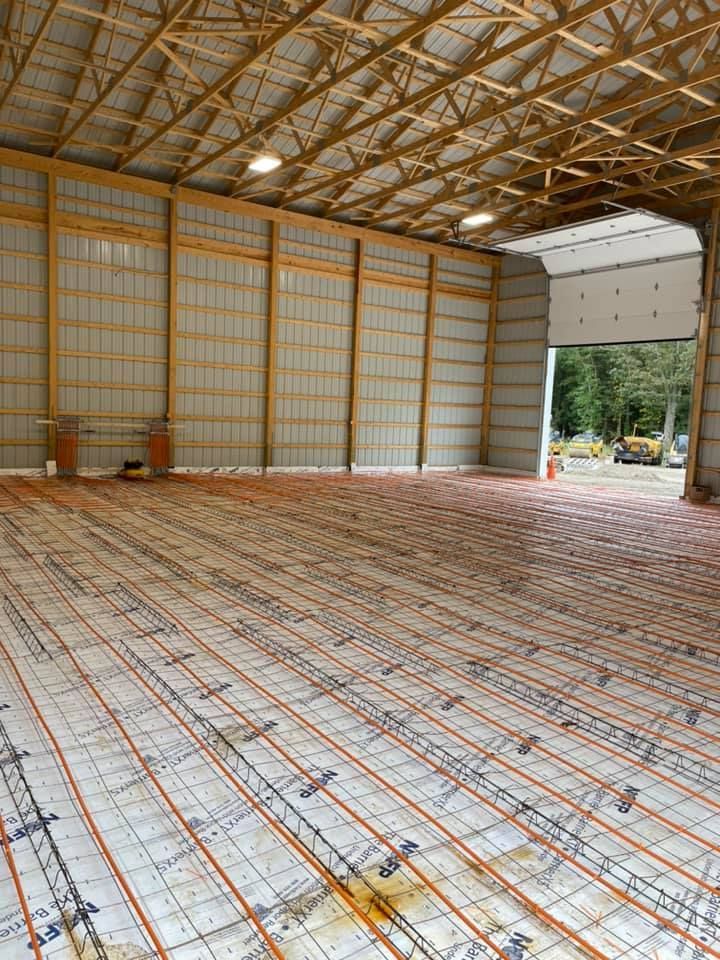 A large warehouse with a concrete floor and a wooden roof.