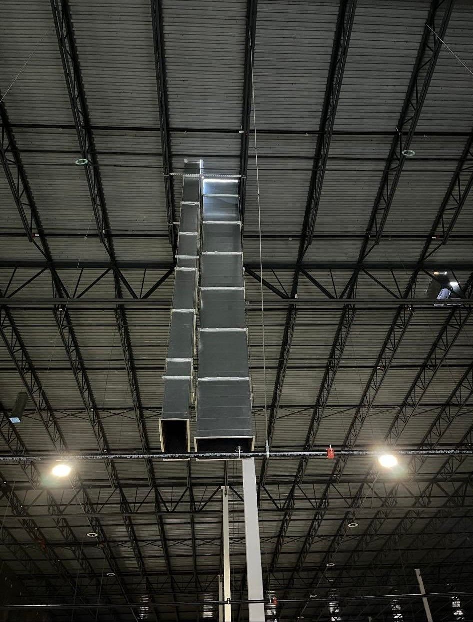 A large metal pipe is hanging from the ceiling of a building.