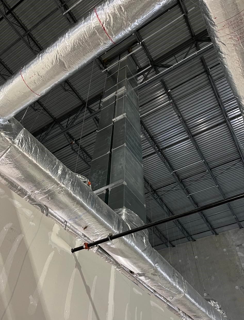 A ceiling with a lot of pipes hanging from it.