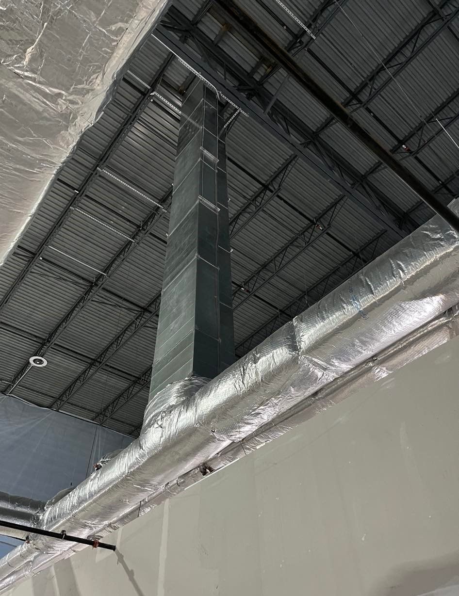 A large pipe is hanging from the ceiling of a building.