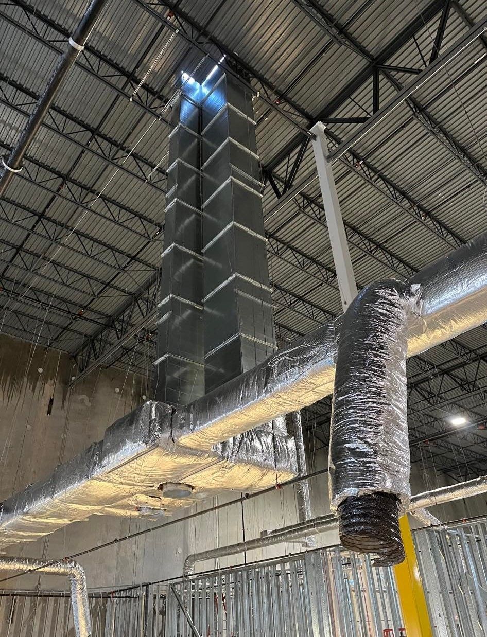 A large metal pipe is hanging from the ceiling of a building.