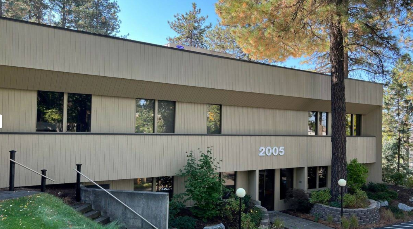 Woman on a couch talks to a person seated in a chair, possibly a therapy session.