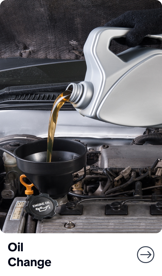 Motor oil pouring into a black funnel during an oil change under a car hood | Bob's Main Street Auto & Towing
