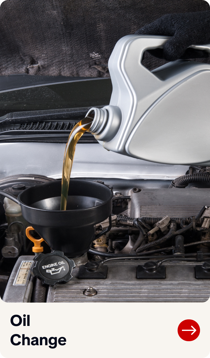 Motor oil pouring into a black funnel during an oil change under a car hood | Bob's Main Street Auto & Towing