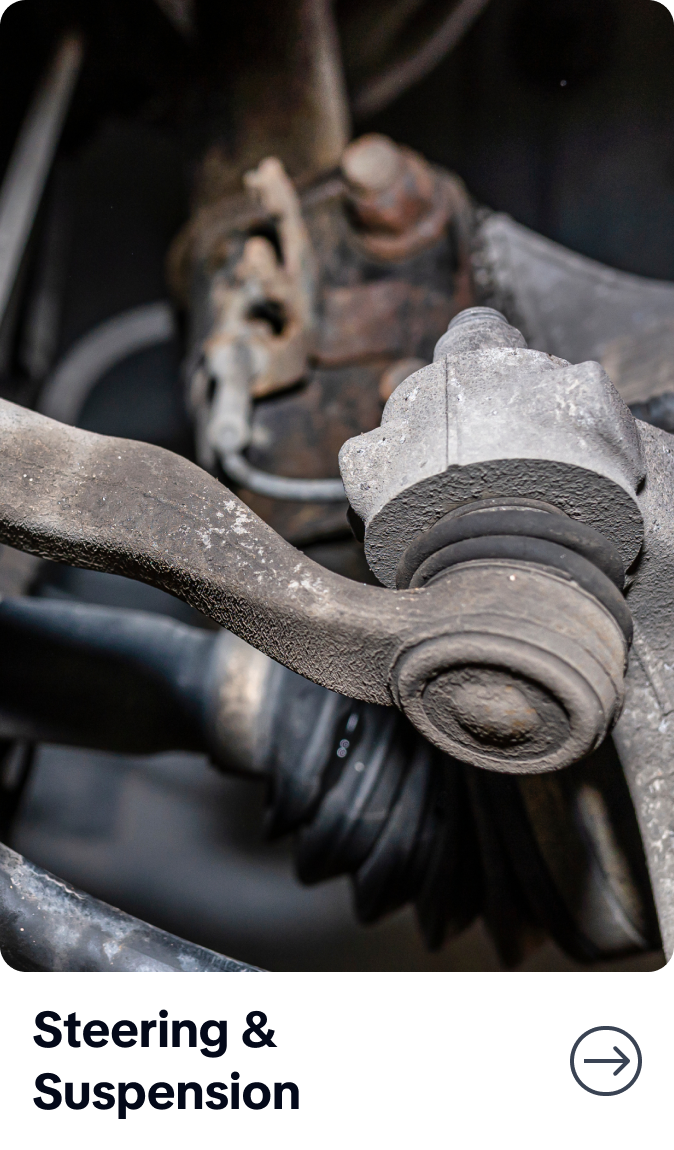 Close-up of a worn car steering suspension joint with rust and grime, labeled “Steering & Suspension.”  | Bob's Main Street Auto & Towing