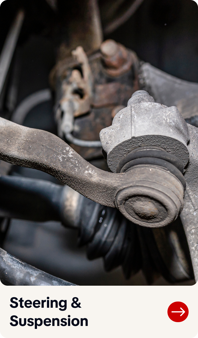 Close-up of a worn car steering suspension joint with rust and grime, labeled “Steering & Suspension.”  | Bob's Main Street Auto & Towing