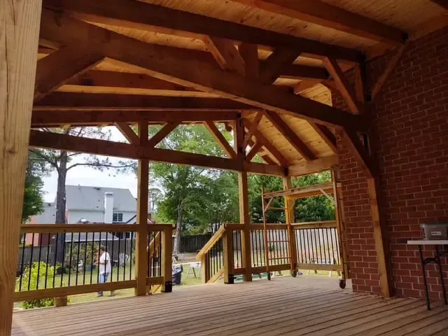 A wooden deck with a brick wall behind it