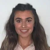 A woman with long hair is smiling for the camera.
