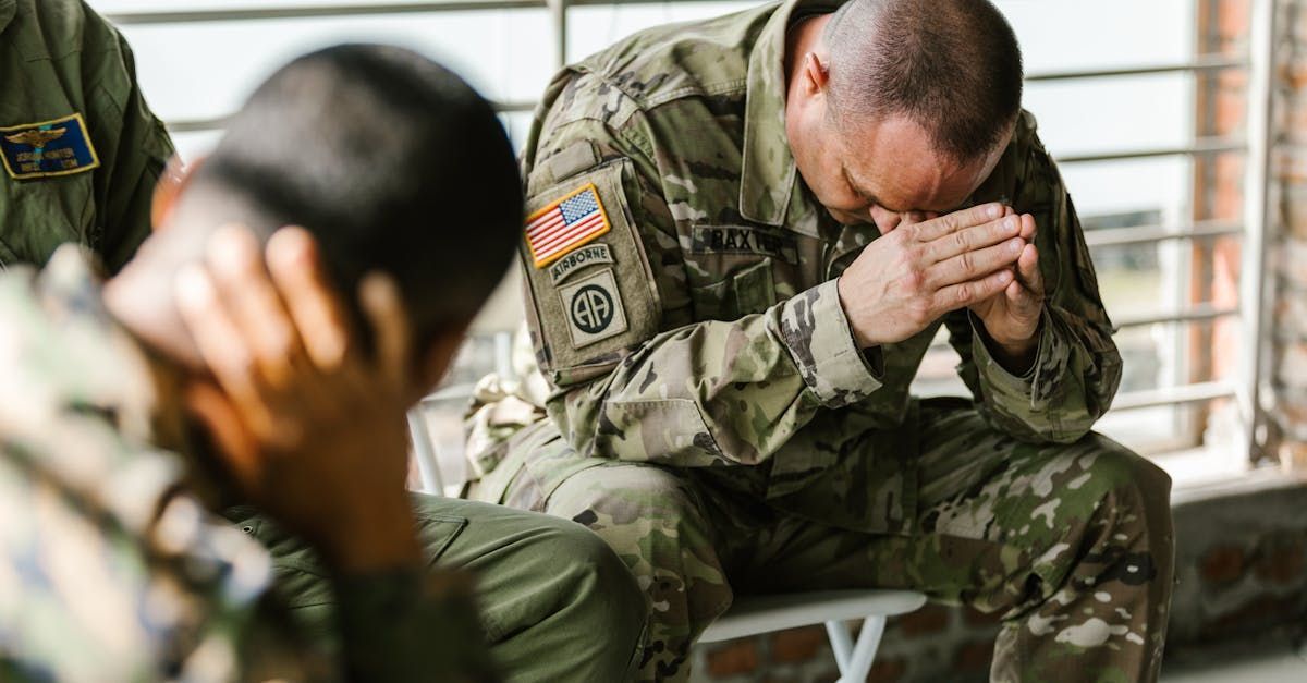 A group of soldiers are sitting on a bench with their hands folded in prayer.