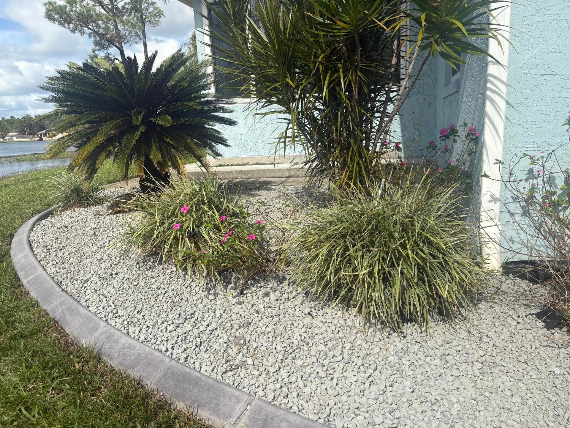 A garden with gravel and plants in front of a house.