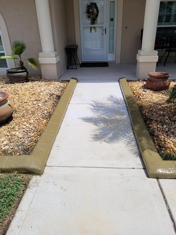 A concrete walkway leading to the front door of a house.
