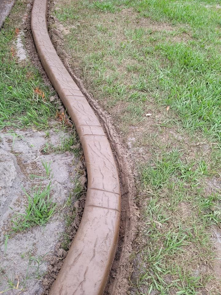 A concrete curb is being installed in a yard.