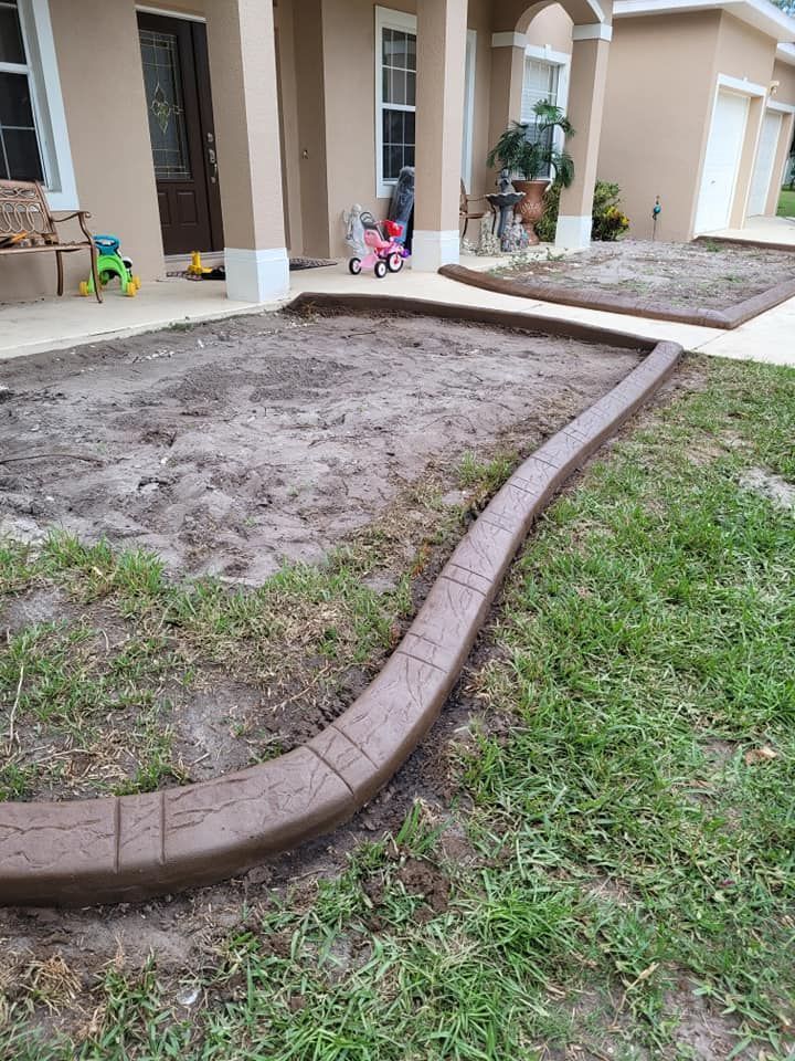 A concrete curb is being installed in front of a house.