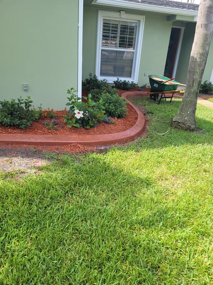 There is a wheelbarrow in the grass in front of a house.