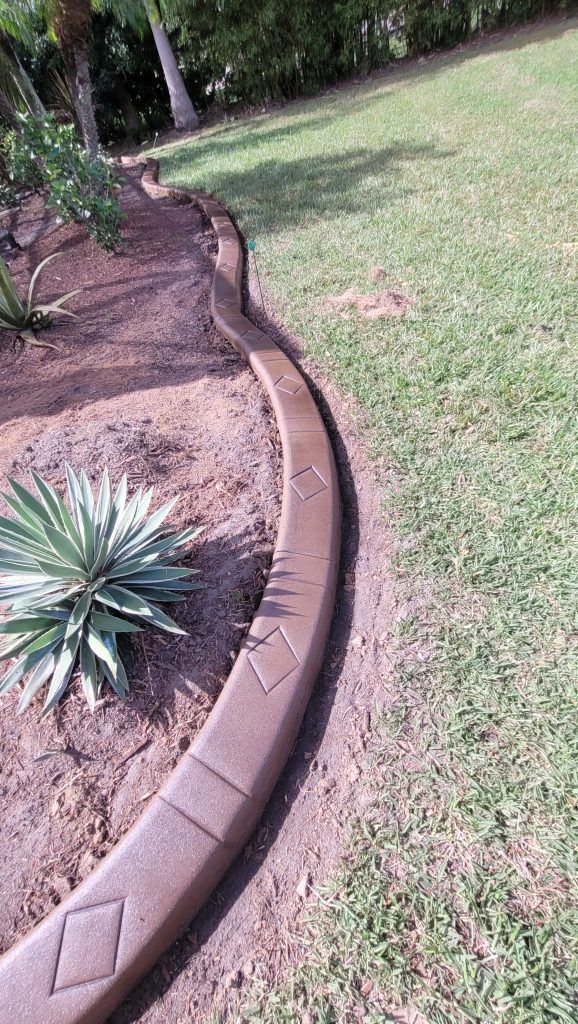 There is a concrete curb in the middle of the yard.