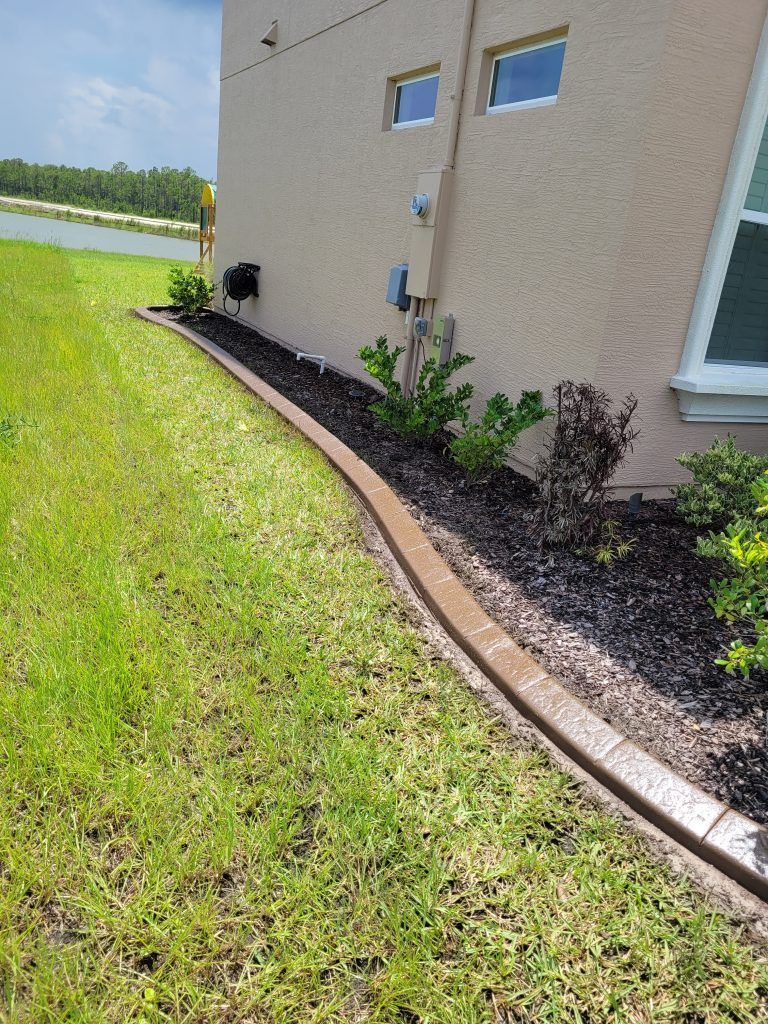 A house with a concrete curb and a lawn in front of it.